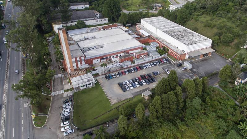 Vista aérea da planta da Chiesi Farmacêutica em Santana de Parnaíba/SP, com galpão logístico e prédios industriais.