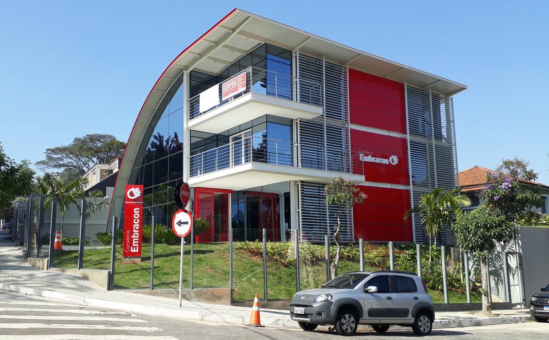 Fachada da nova unidade da Embracon em São Paulo, com cobertura curva, brises metálicos e painéis vermelhos.