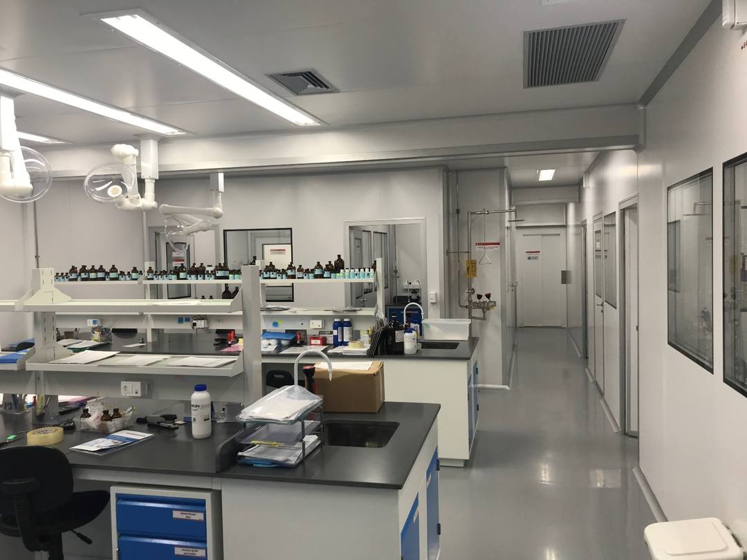 Laboratório concluído com bancadas, prateleiras de reagentes e piso técnico na Farmarin em Guarulhos/SP.