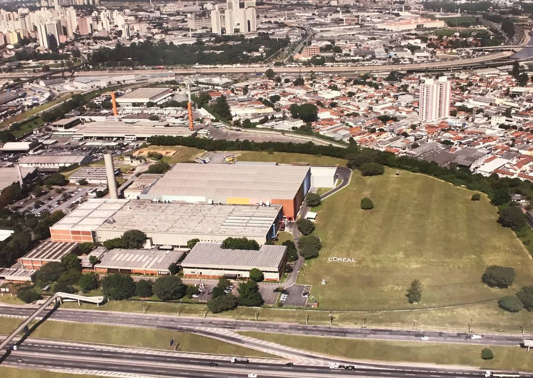 Vista aérea da unidade Procosa da L'Oréal em São Paulo/SP, com prédios fabris e gramado com o logotipo.