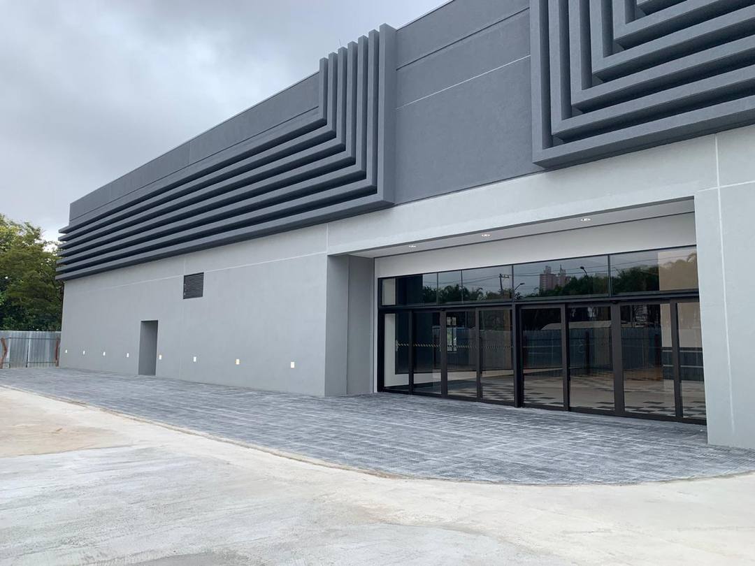 Fachada da expansão do Shopping SP Market, em São Paulo, com revestimento cinza, brises horizontais e portas de vidro na entrada.